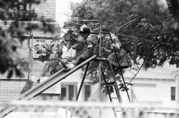 A white girl follows a black girl down the slide at Thomas J. Semmes school in New Orleans during recess on Sept. 7, 1962